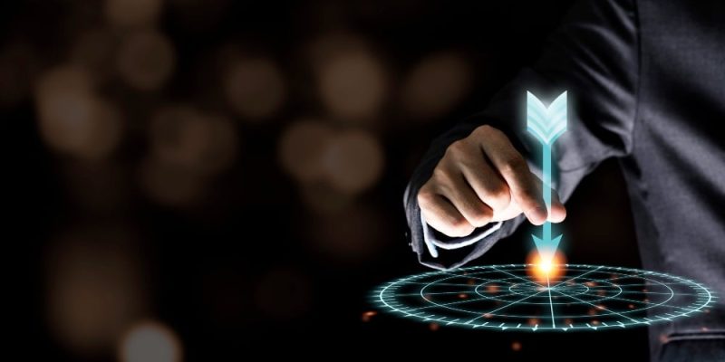 businessman-hand-holding-and-throwing-virtual-dart-to-target-board-on-black-wall-business-and-investment-target-concept-compressed